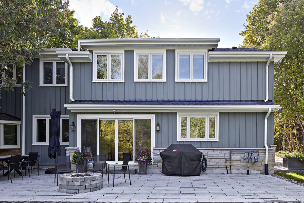 Back view of cottage renovation with patio and fireplace 