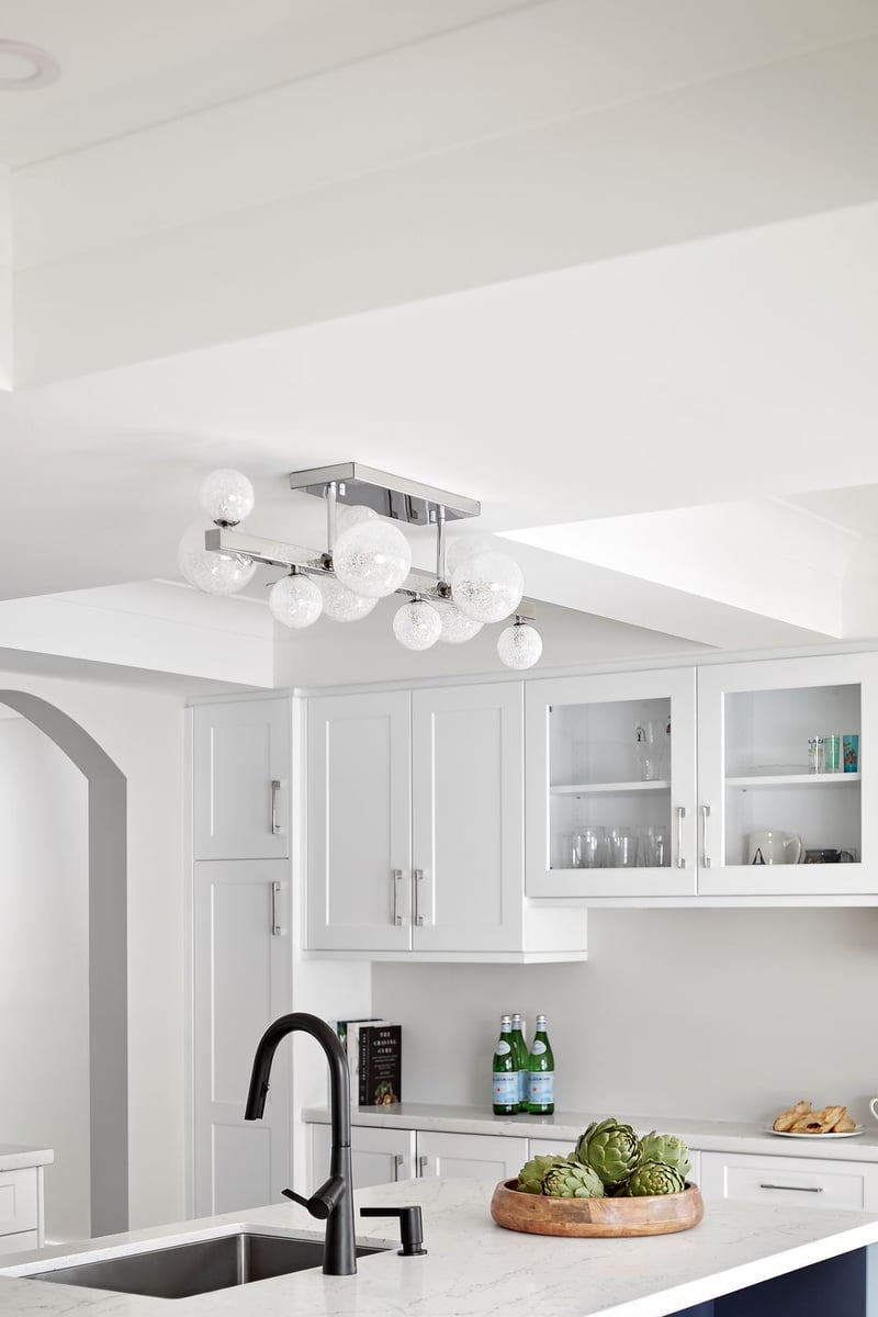 Circular bulb pendant lighting above white island in Markham luxury kitchen renovation