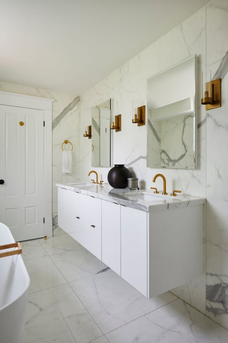 Floating double vanity with brass faucets and all marble bathroom in Markham, Ontario