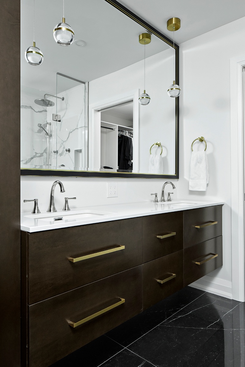 Dark wood double vanity with brass pulls and white countertops in Markham renovation by Master Edge Homes