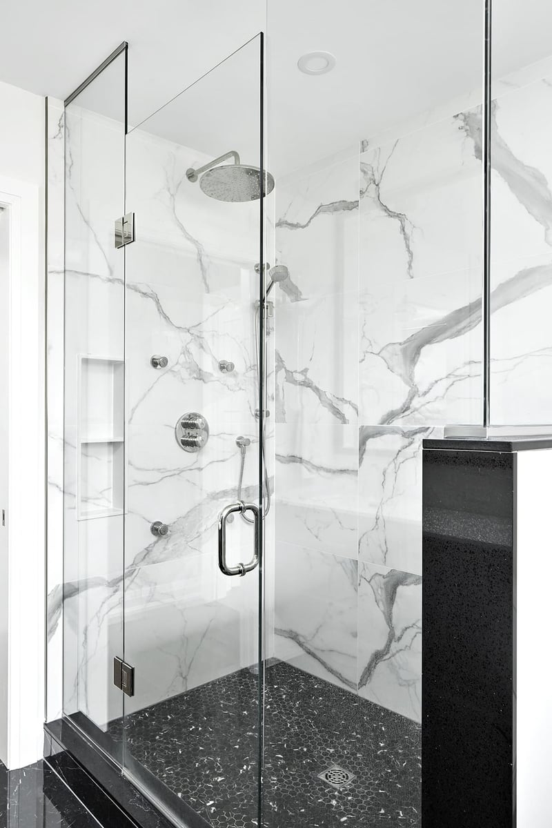 Frameless walk-in shower with small format floor tile and rain shower head in Markham home renovation