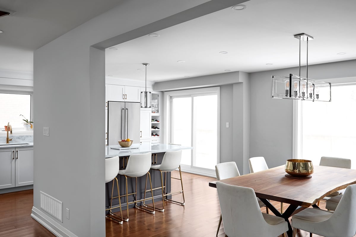 Open-concept kitchen layout with dining room table beneath light fixture by sliding glass door in Markham kitchen renovation