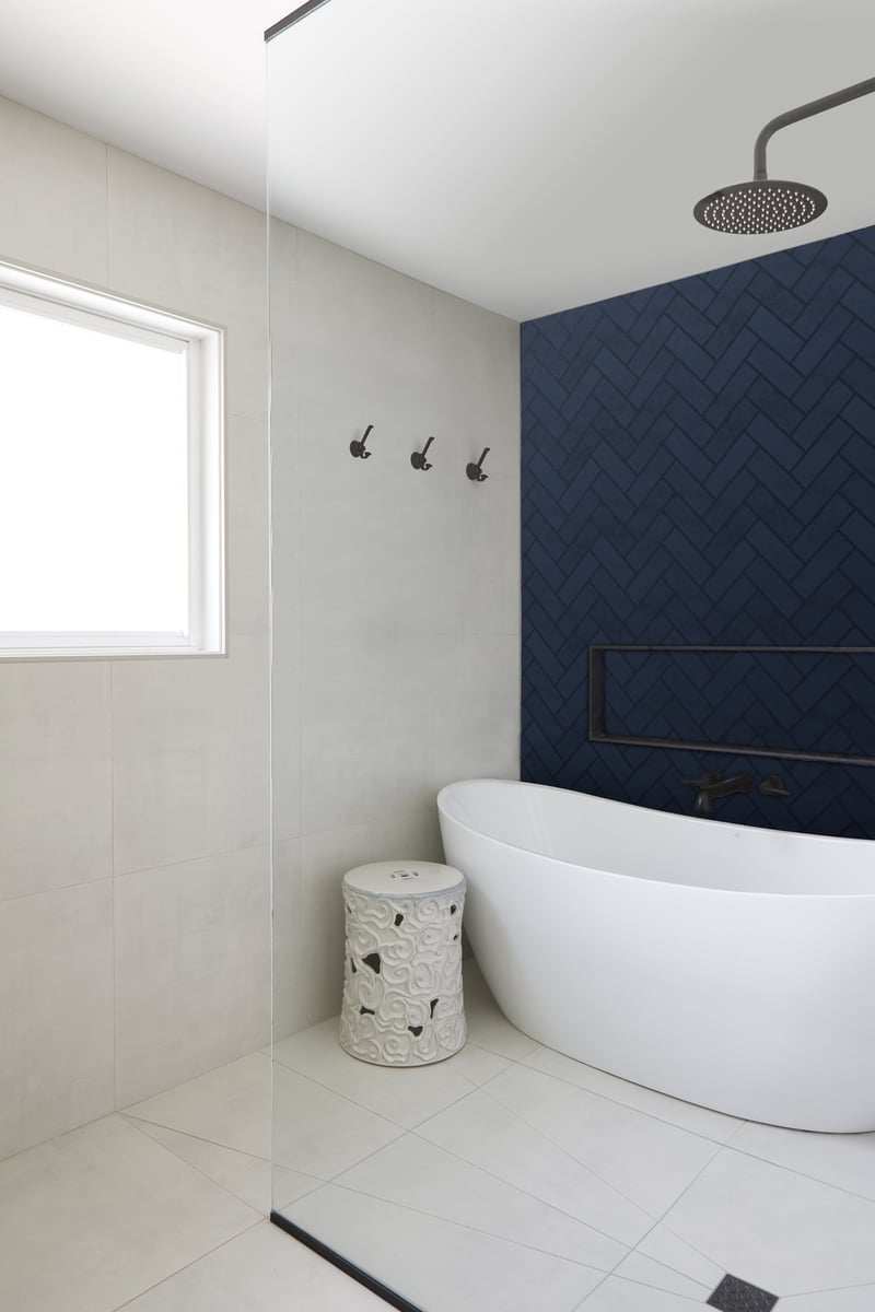 Primary suite with wet room and blue herringbone tile by Master Edge Homes